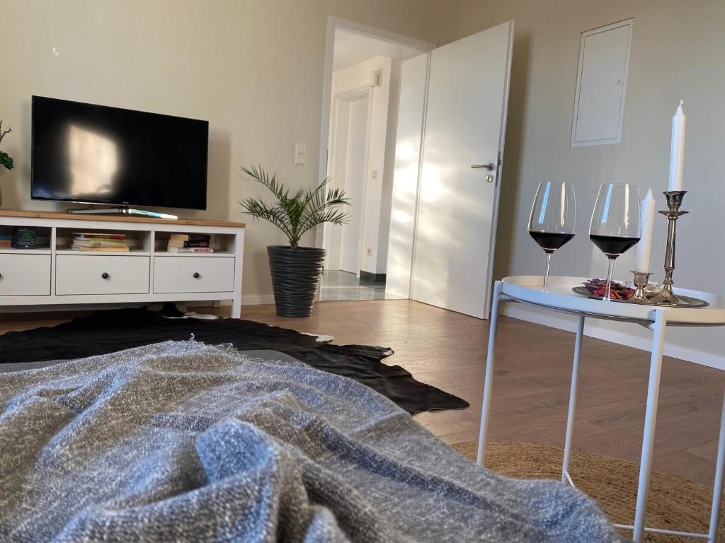 a living room with two wine glasses and a tv at Ferienwohnung Luzi in Küllstedt