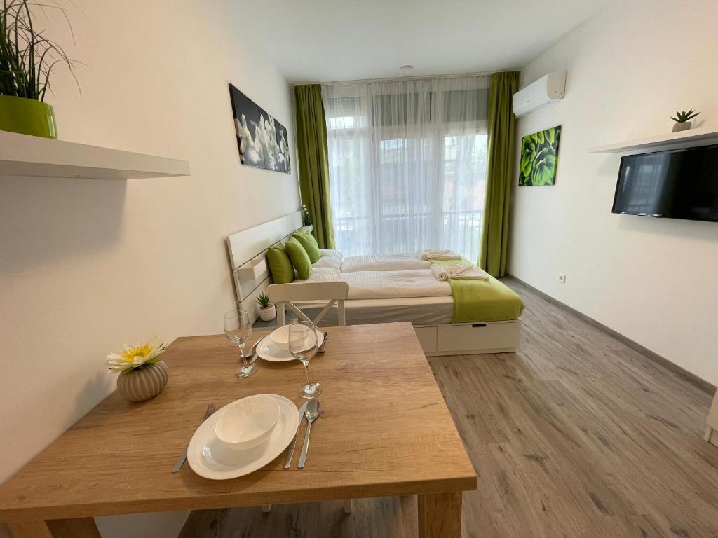 Zimmer mit einem Bett und einem Holztisch in einem Zimmer in der Unterkunft Siesta Apartman in Balatonberény