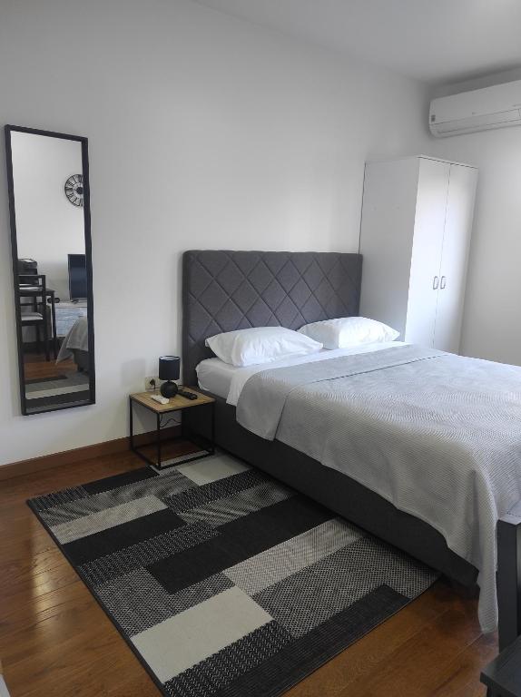 a bedroom with a large bed and a rug at Studio K in Podgorica