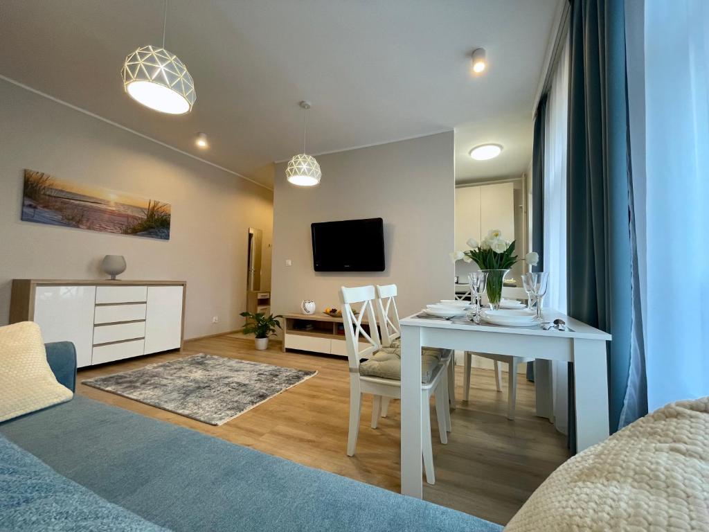 a living room and dining room with a table and chairs at Apartament Seabella blisko plaży Gdańsk Brzeżno in Gdańsk