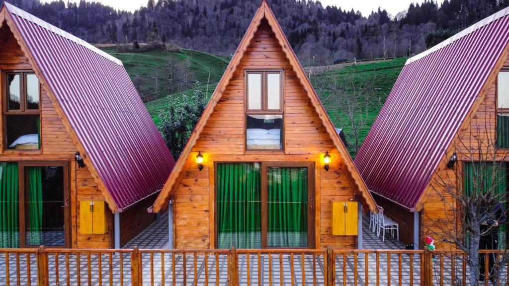 una cabaña de madera con una valla delante en Bungi dağ evleri, en Rize