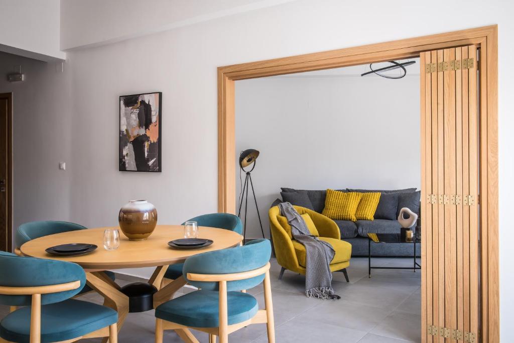 uma sala de estar com uma mesa e cadeiras e um sofá em Loggia Suites by Good Life em Iráclio