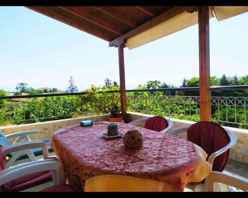- une table et des chaises sur une terrasse avec vue dans l'établissement SEA VIEW MAISONETTE Netflix, à Néa Kerasiá