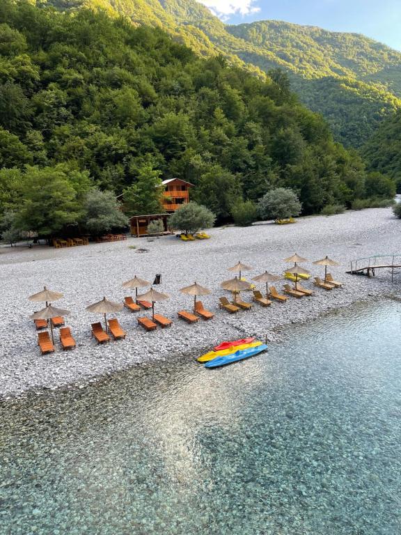 un grupo de sillas y sombrillas en una playa en Guri i Lekës Guesthouse, en Shkodër