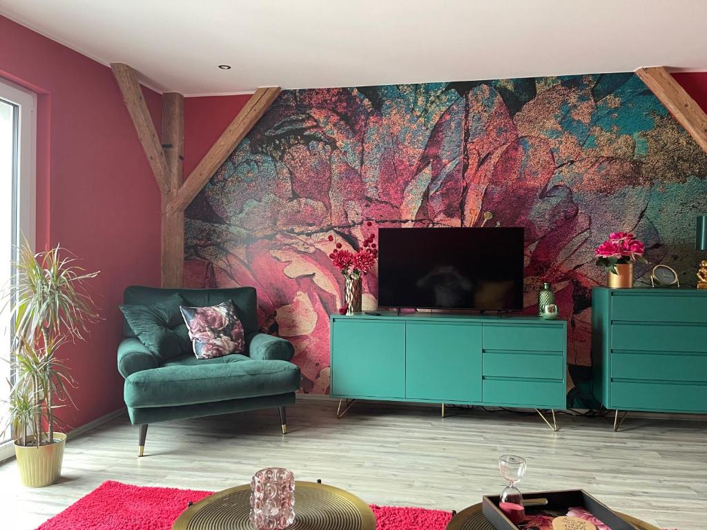 uma sala de estar com uma cadeira verde e uma televisão em Ferienwohnung Thiele in Rosswein em Roßwein