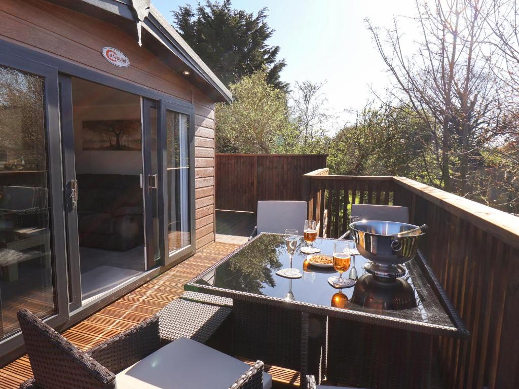a patio with a table and chairs on a deck at Marigold Lodge in Saltburn-by-the-Sea