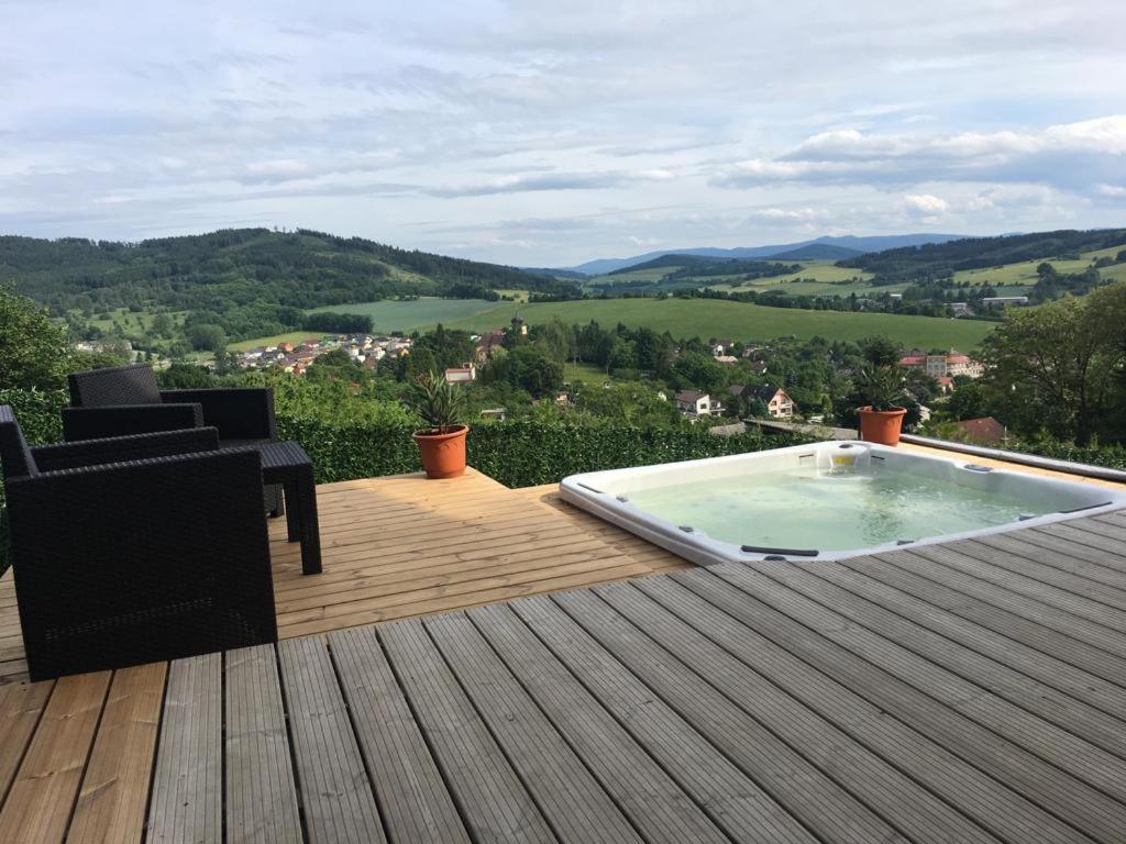 een hot tub op een houten terras met uitzicht bij Kellys SPA in Kdyně