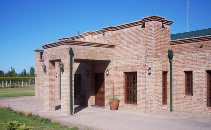 un edificio de ladrillo rojo con una maceta en la puerta en Finca La Carmelita en San Rafael