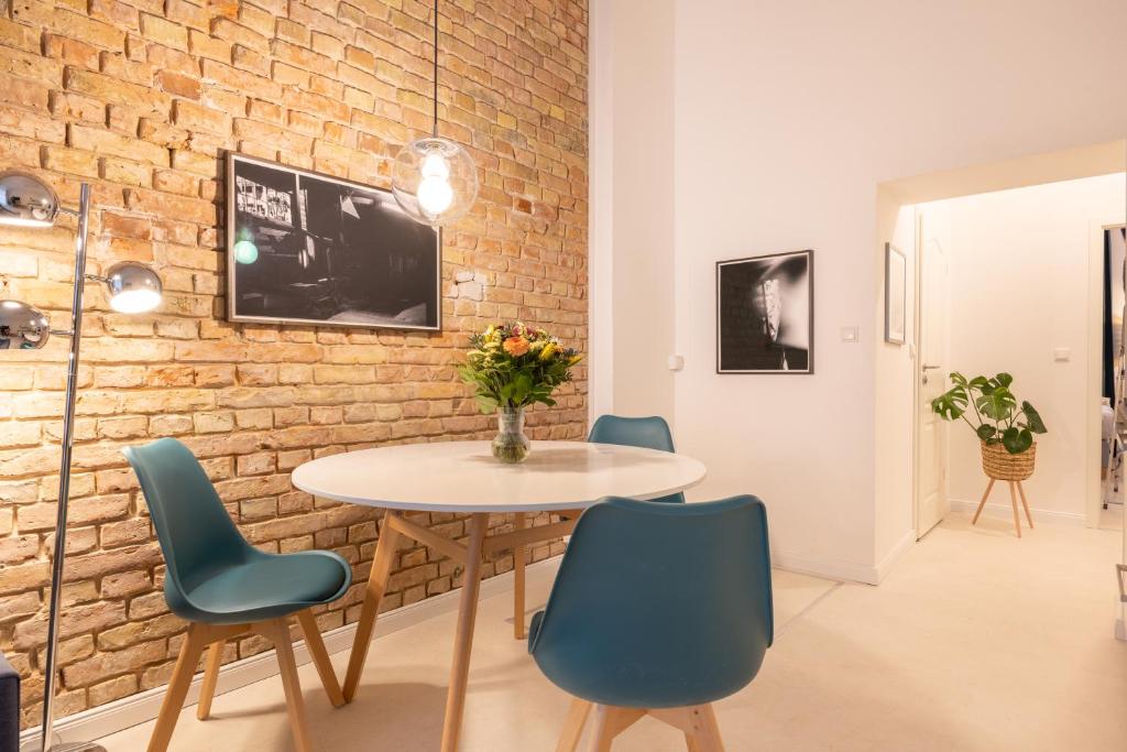 a dining room with a table and chairs and a brick wall at Great 2-room apartment in Berlin