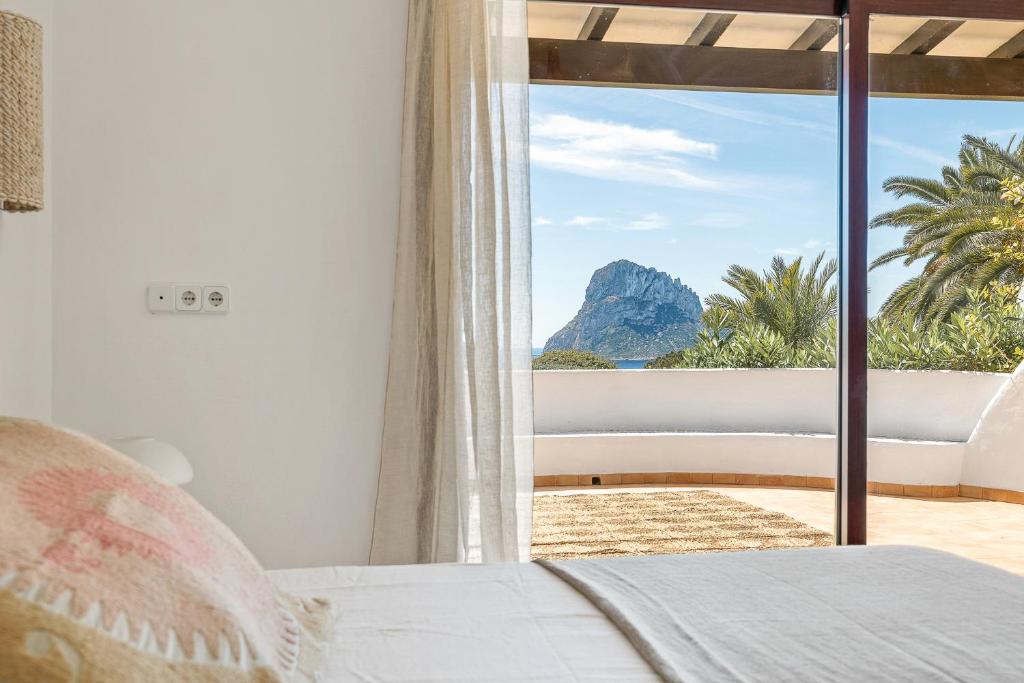 a bedroom with a bed and a view of the ocean at UNIO Ibiza - Adults Only in Cala Vadella