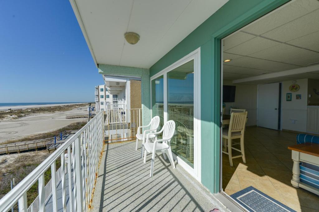 a house with a balcony with chairs and a table at Stunning Beachfront Condo with Panoramic Ocean View in Wildwood Crest