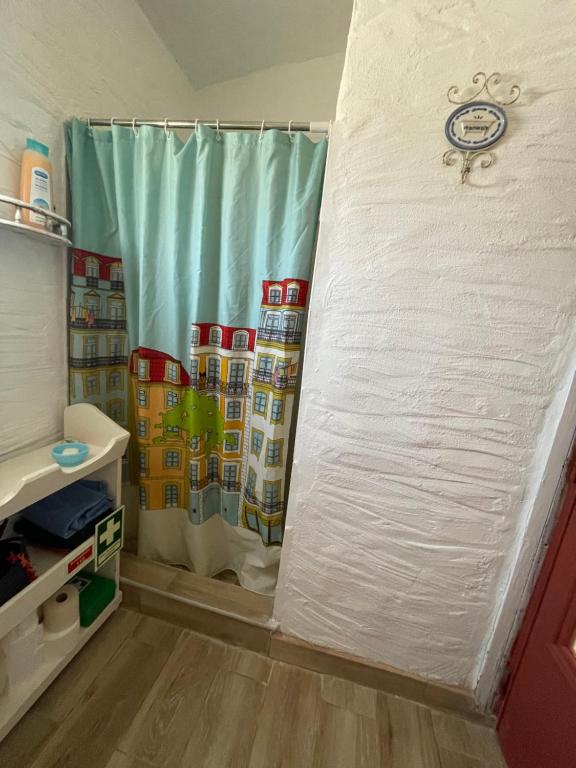 Habitación con baño con cortina de ducha. en Monte Carrascal Guesthouse, en Salir