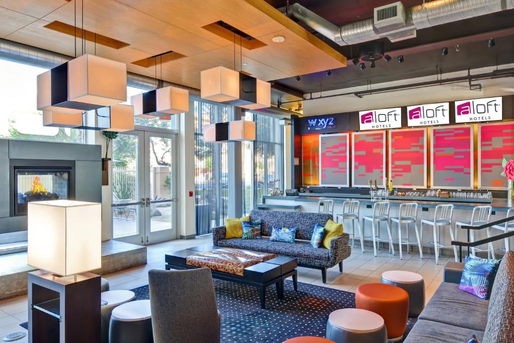 a lobby with a couch and a bar at Aloft Phoenix Airport in Phoenix