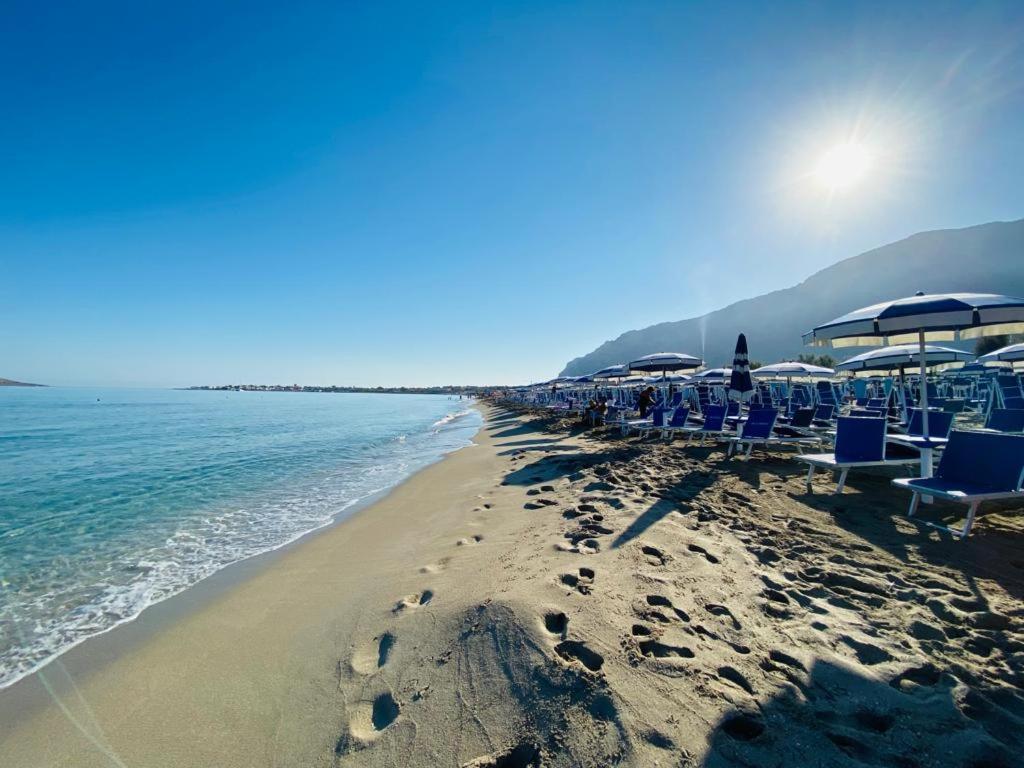 a beach with chairs and umbrellas and the ocean at Casa delle Sirene in Isola delle Femmine