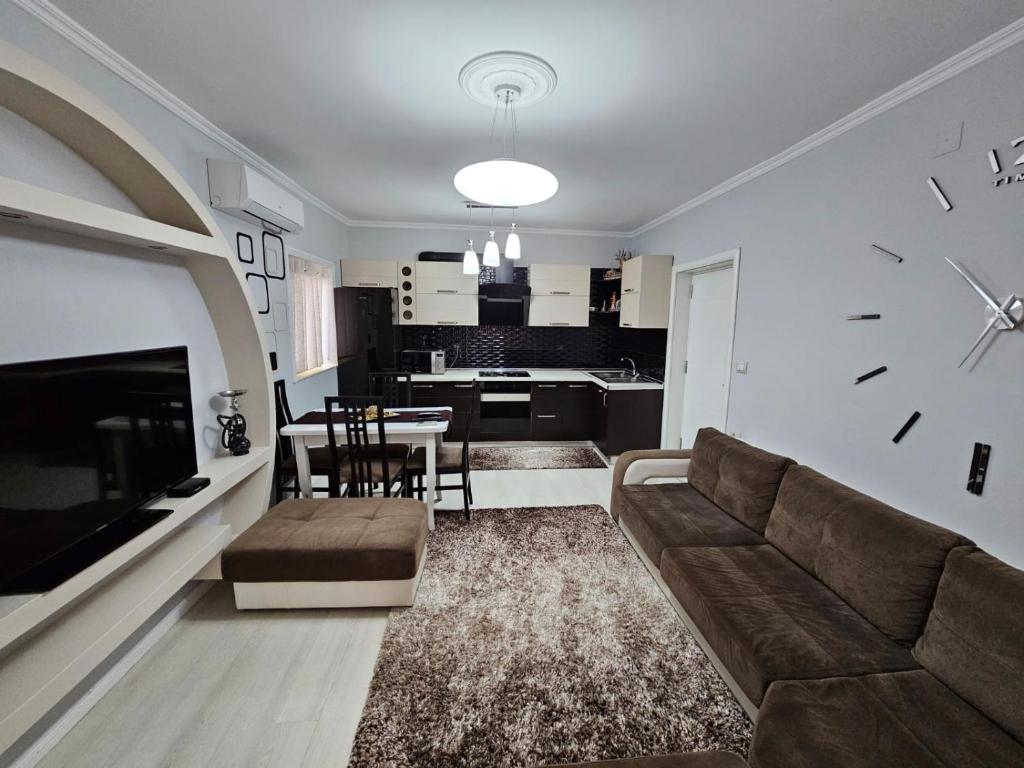 a living room with a couch and a dining room at Bala Apartment in Shkodër