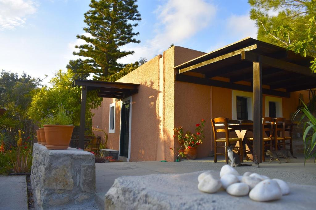 a house with a patio with a table and chairs at Anemos - Holiday Beach Houses in Keratokampos