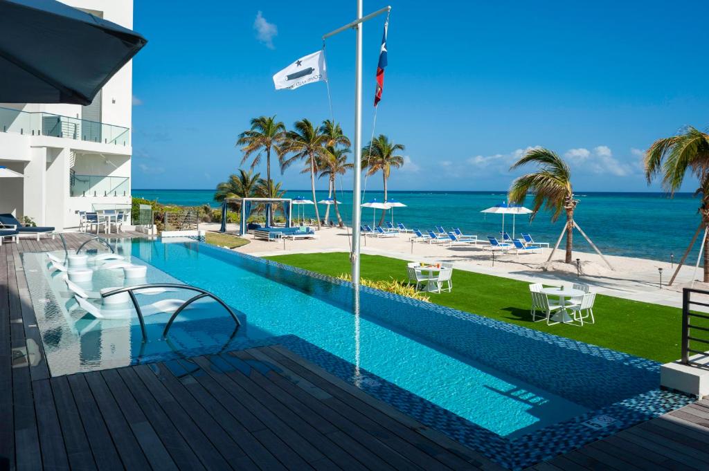 a swimming pool with a view of the beach at Club Suites at Rum Point in Driftwood Village