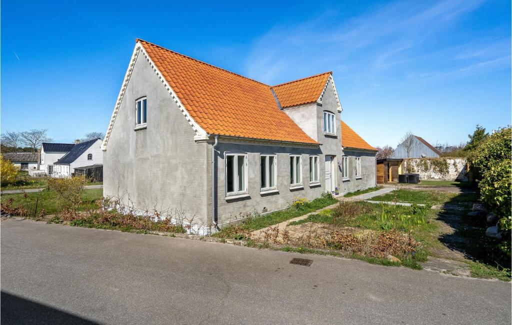 3 Bedroom Awesome Home In Sams في Nordby: منزل بسقف برتقالي على شارع