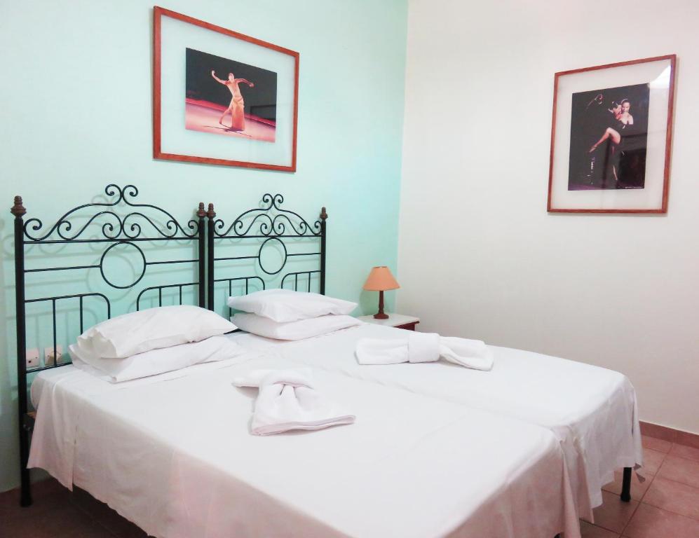 a bedroom with a large white bed with white sheets at Avlitis in Ermoupoli