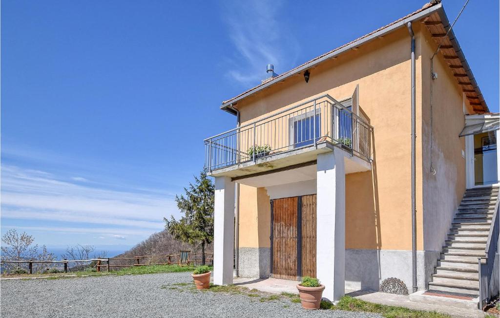 uma casa com uma varanda e uma porta em Nice Home In Castiglione Chiavarese With Kitchen em Castiglione Chiavarese