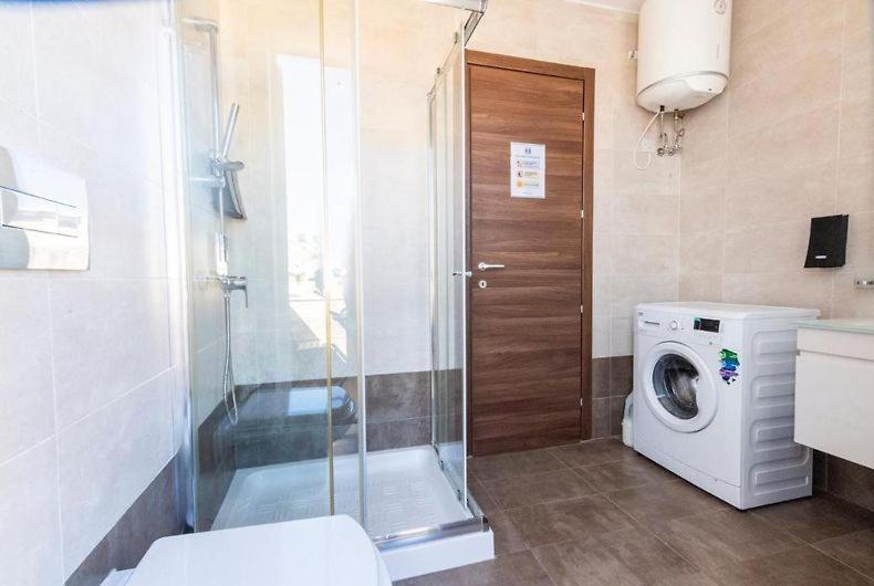La salle de bains est pourvue d'un lave-linge et d'un lave-linge. dans l'établissement The Caves Apartments, à San Ġiljan