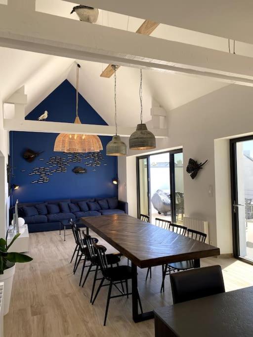 une salle à manger avec une grande table et des chaises en bois dans l'établissement La Cabane des Pêcheurs, à Quiberon