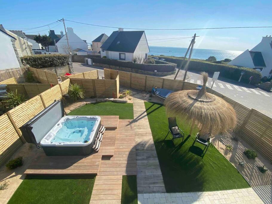 a backyard with a swimming pool and an umbrella at La Cabane des Pêcheurs in Quiberon