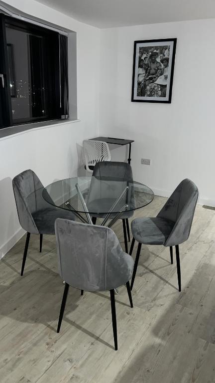 a glass table and chairs in a room at Luxurious City View Apartment in Salford in Manchester