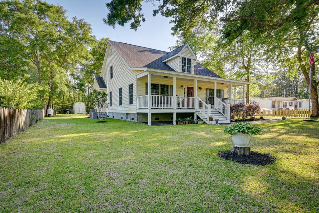 a white house with a porch and a yard at Homey Murrells Inlet Vacation Rental Near Marina in Myrtle Beach