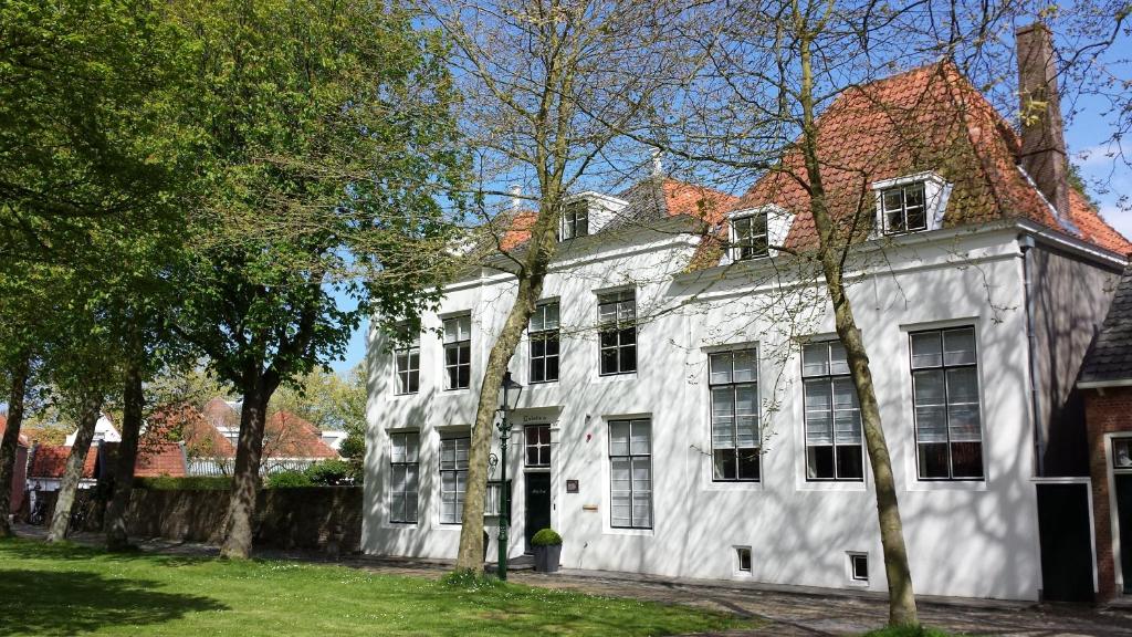 a white house with trees in front of it at Bed en Brood - Veere in Veere