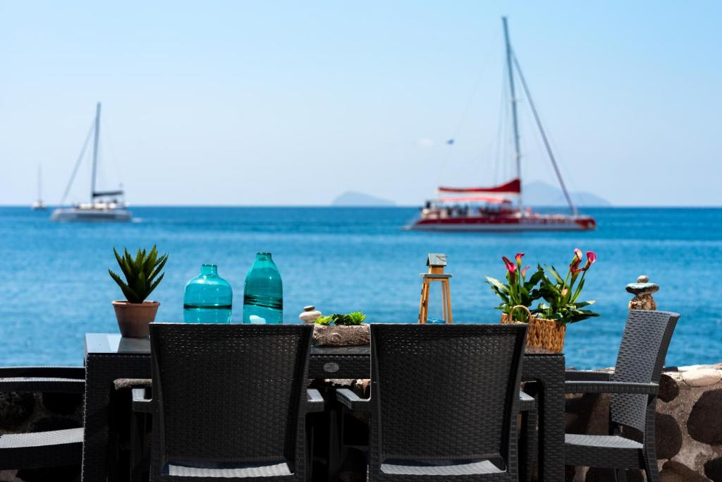 - une table avec des chaises et une vue sur l'océan dans l'établissement Serenity Blue (Cave house), à Akrotiri