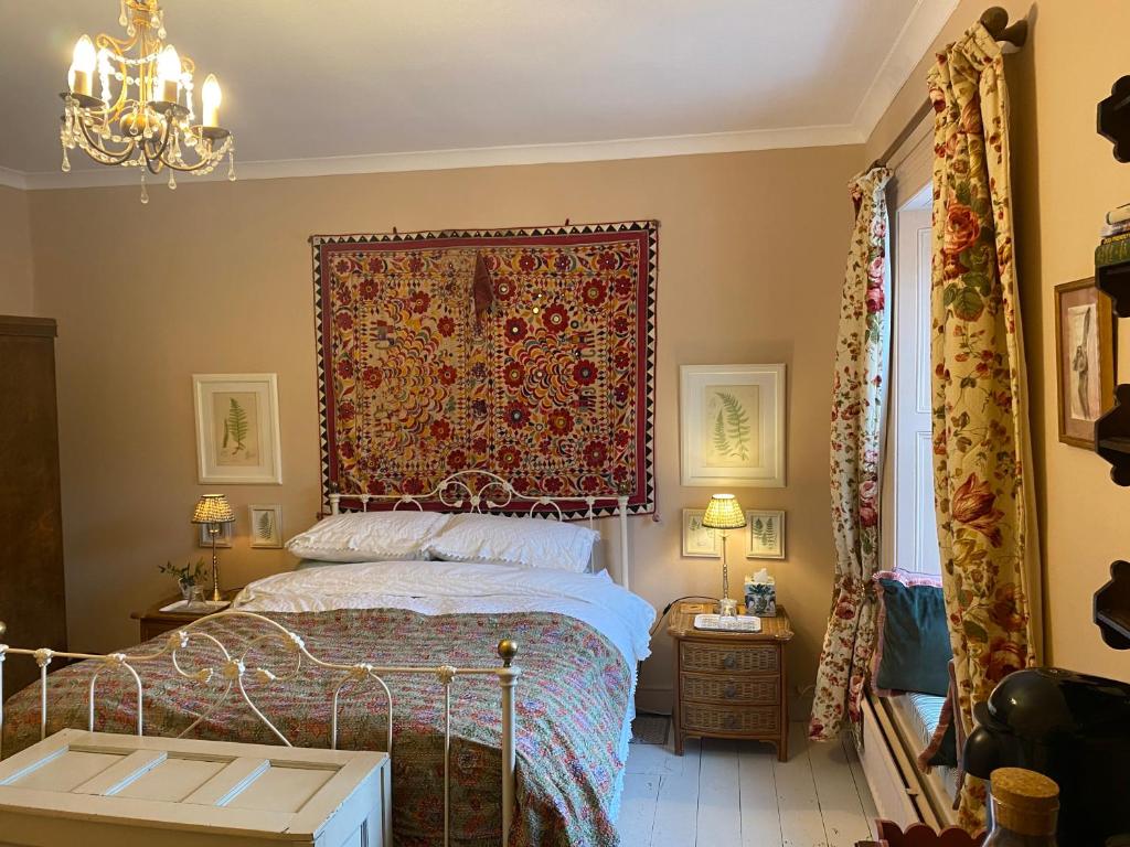 a bedroom with a bed with a red headboard at Historic House in Beatrix Potter Village in Near Sawrey
