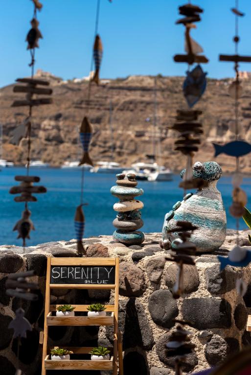 a stone wall with a sign and a stack of rocks at Serenity Blue (Cave house) in Akrotiri