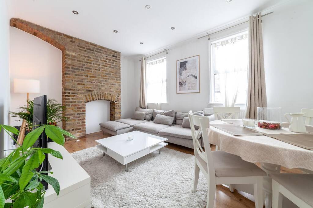 een woonkamer met een bank en een tafel bij 2 Bedroom Duplex Apartment in Londen