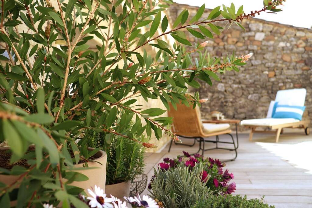 a patio with a chair and some plants and flowers at Uzès médiévale l'écrin d'Amalia in Uzès