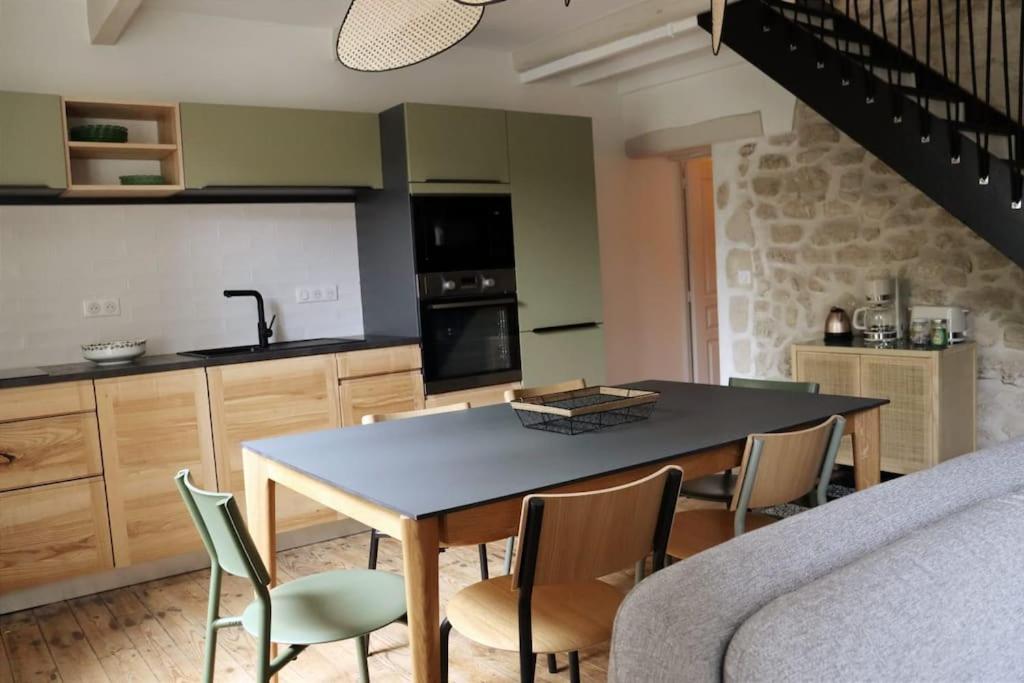 a kitchen with a table and chairs in a room at Uzès médiévale l&#39;écrin d&#39;Amalia in Uzès