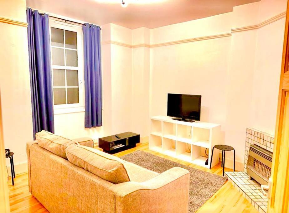 a living room with a couch and a television at Tower Bridge! Immaculate One Bed in London