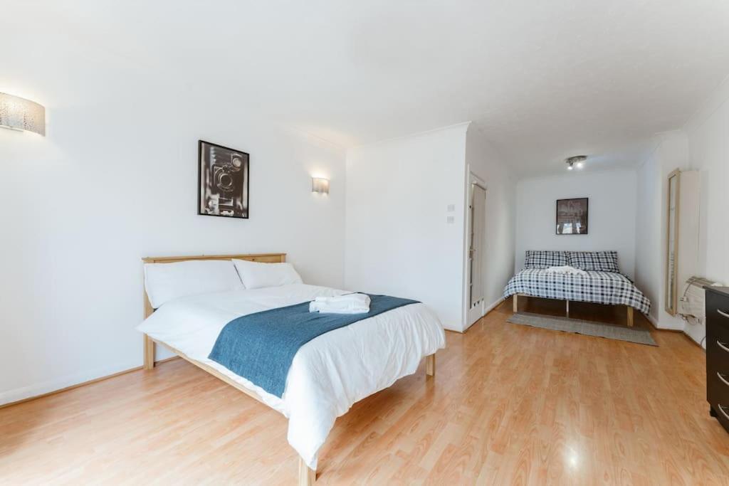 a bedroom with a large white bed and a wooden floor at Up to 4 people, Room In a Share house next to London Bridge in London