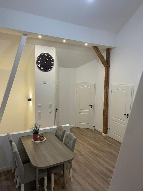 a dining room with a table and a clock on the wall at Stilvolle Ferienwohnung bei Bad Segeberg in Blunk