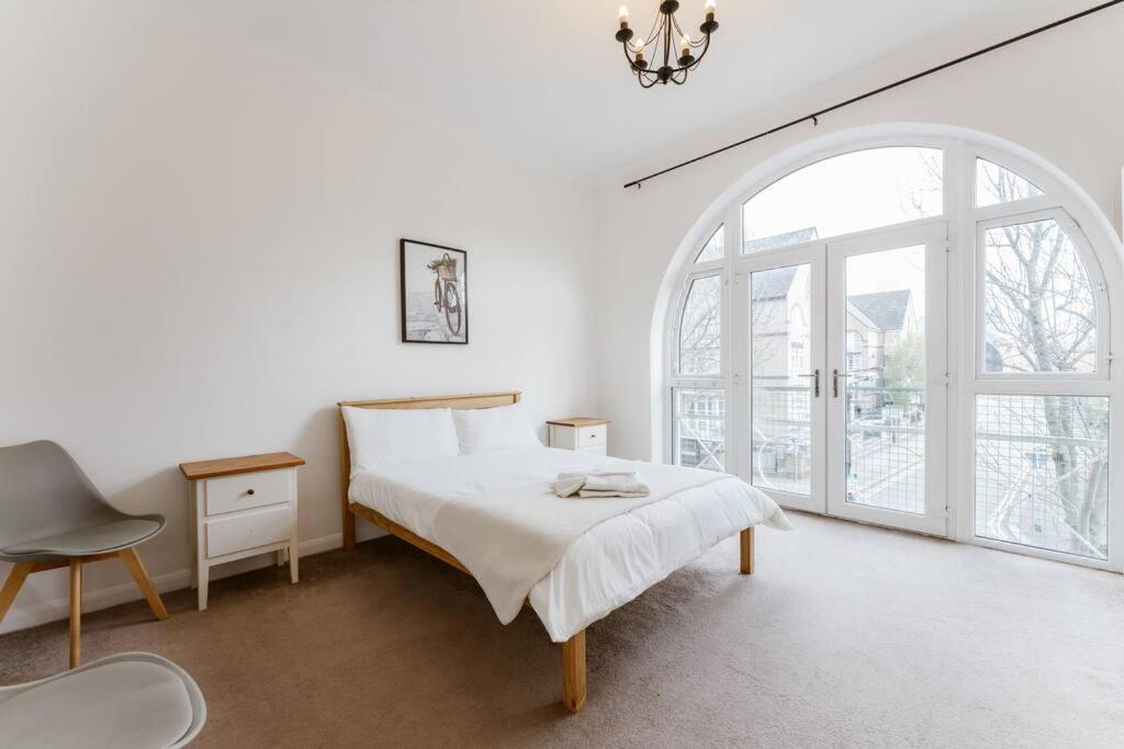 a white bedroom with a bed and a window at Spacious Ensuite Room Near Top Tourist Attractions in London