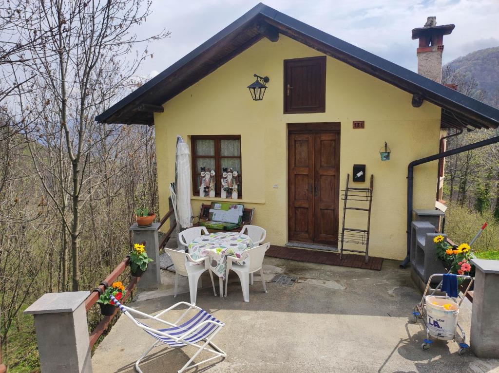 a small yellow house with a table and chairs at Casa di Viu' in Viù