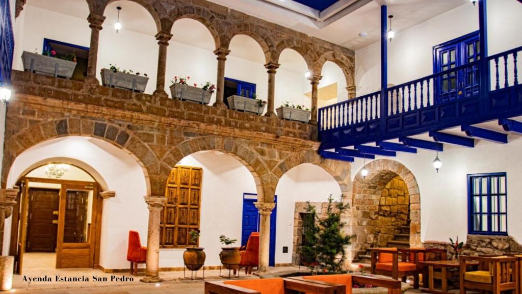 a building with arches and balconies and tables at Estancia San Pedro Hotel in Cusco