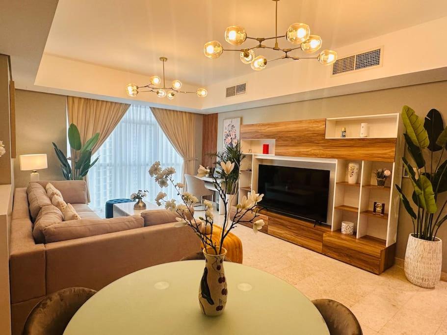 - un salon avec un canapé et une table dans l'établissement Ocean Terrace Apartment, à Abu Dhabi