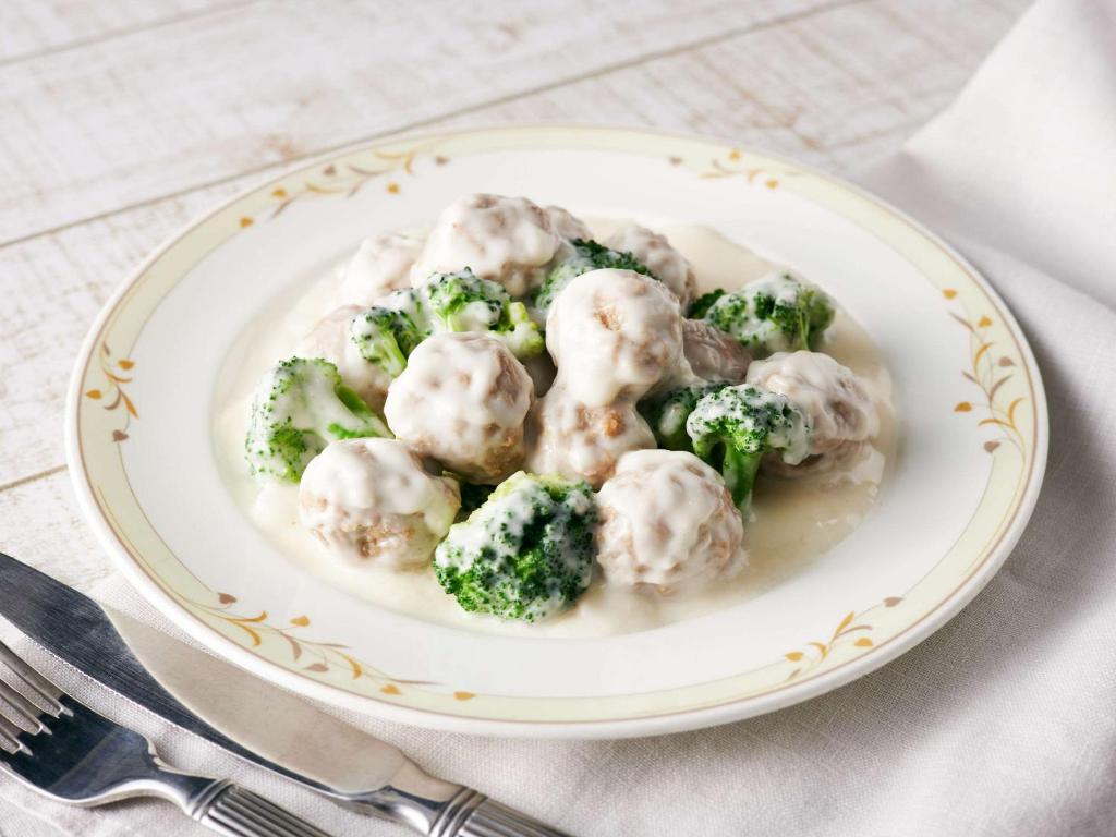 a plate of dumplings and broccoli on a table at Comfort Hotel Central International Airport in Tokoname