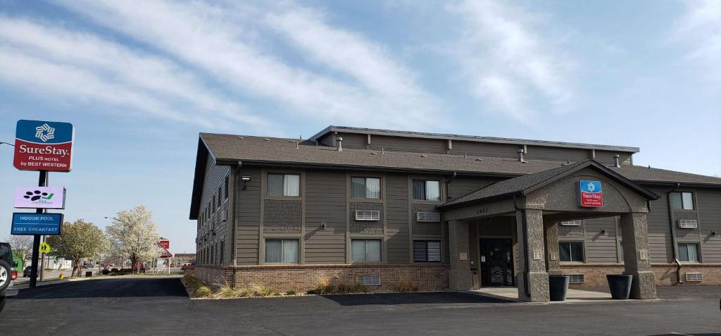 a brown building with a sign in front of it at SureStay Plus Hotel by Best Western Grand Island in Grand Island