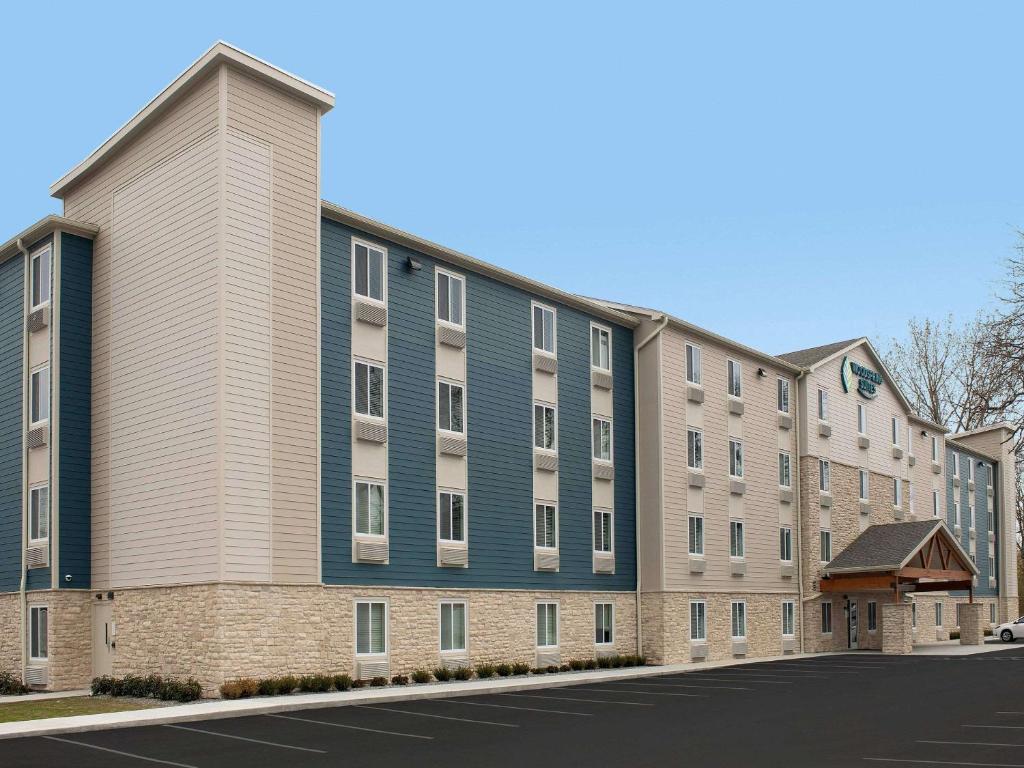 een appartementencomplex met een blauw-wit gebouw bij WoodSpring Suites Rochester Greece in Rochester