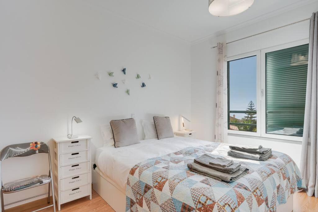 Un dormitorio blanco con una cama y una ventana. en Alta do Garajau II, en Caniço