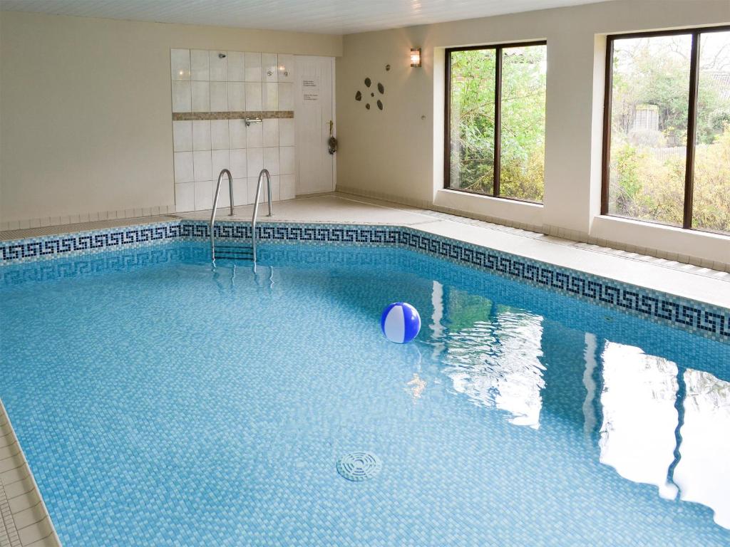 a swimming pool with a ball in the water at Riverside Cottage in Costessey