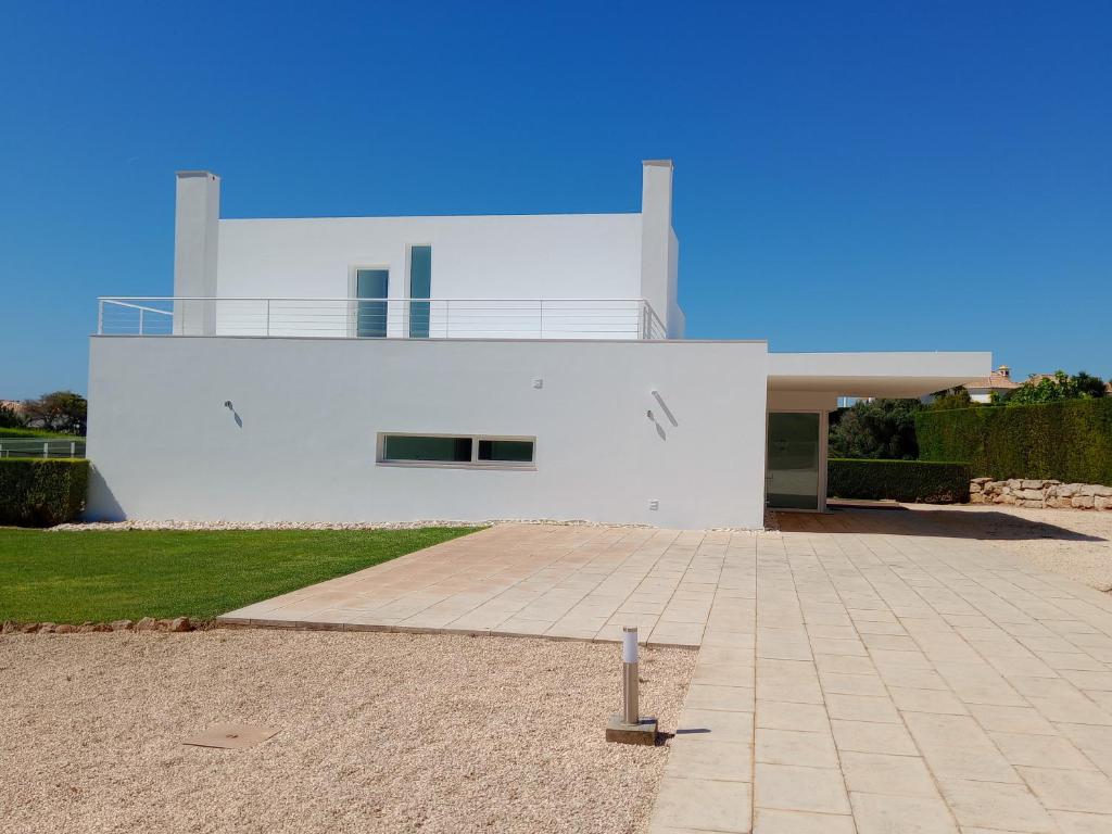 a large white house with a roof at White beach luxury vila in Sagres