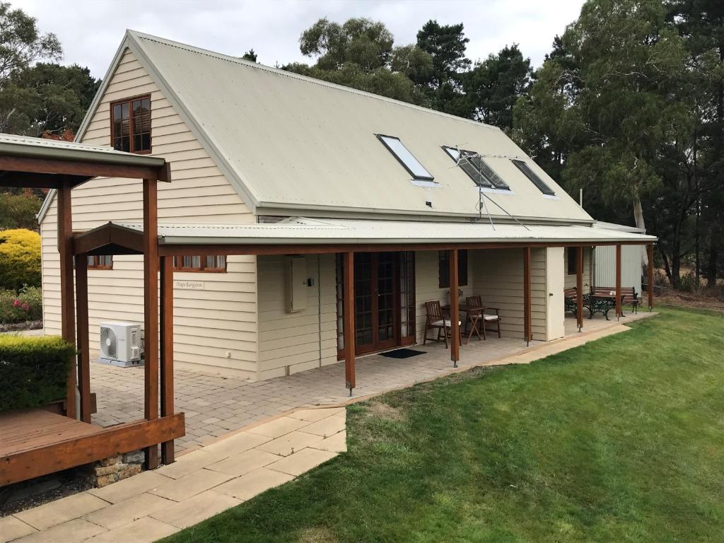 a white house with a roof with a patio at Otago Cottage in Hobart